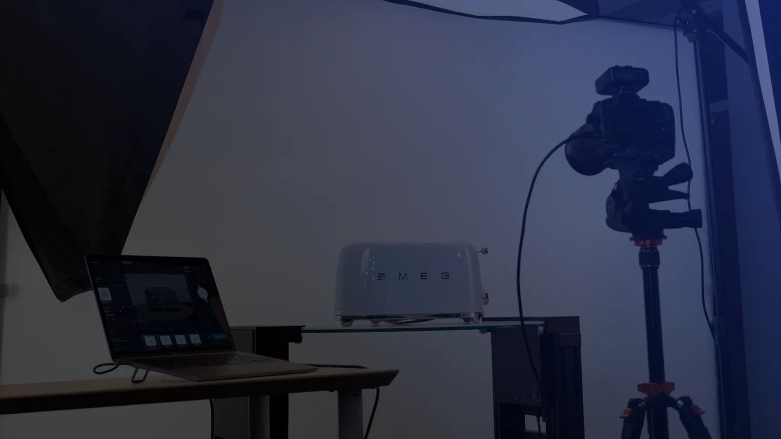 テザリング撮影の商品撮影セット。撮影ソフトを表示したノートPC、三脚上のカメラ、ガラス棚の上の商品