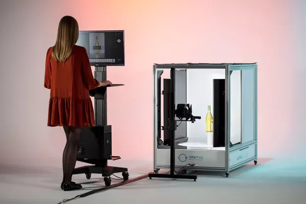 Woman operating automated product photography booth