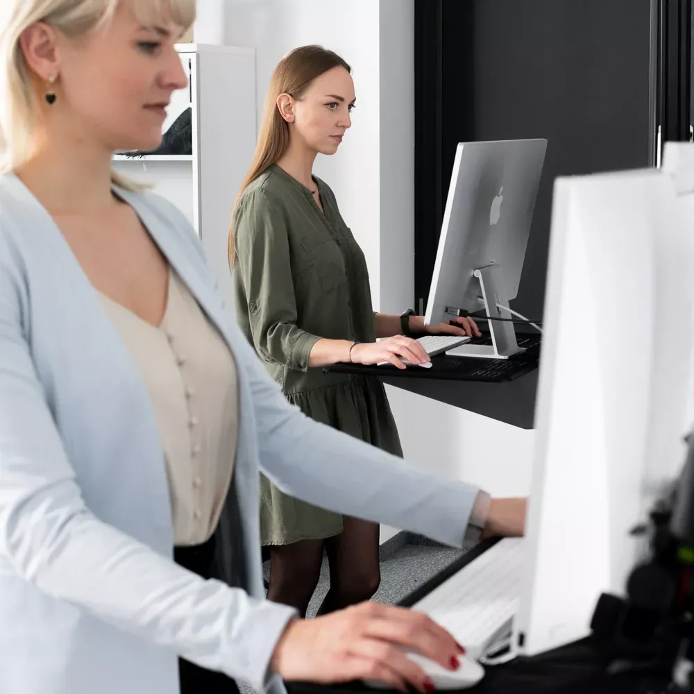 Product photography editors working at standing workstations